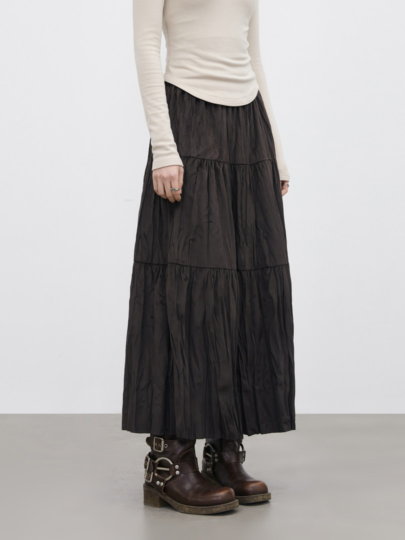 Model wearing a black tiered maxi skirt with brown lace-up ankle boots