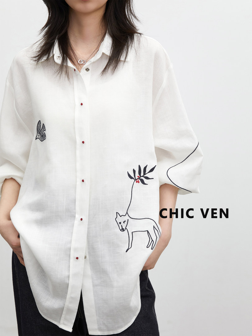 White oversized button-up shirt with black line-art animal and floral embroidery worn by a model