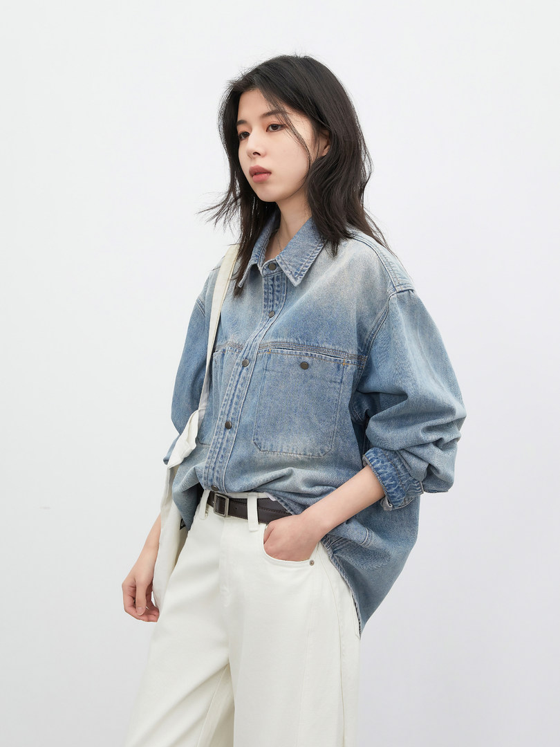 Model wearing a light blue denim shirt with white pants
