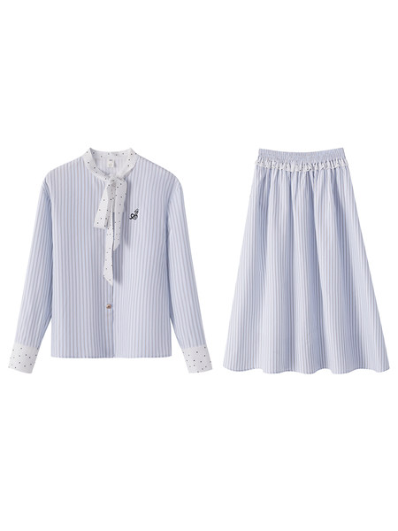 Model wearing a light striped matching blouse and skirt set with a tote bag