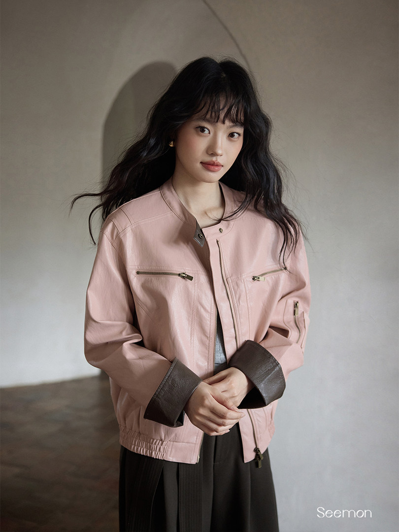 Model wearing a light pink zip-front jacket with dark cuffs