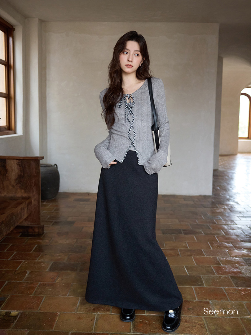 Model wearing a gray long-sleeve knit top with a black maxi skirt