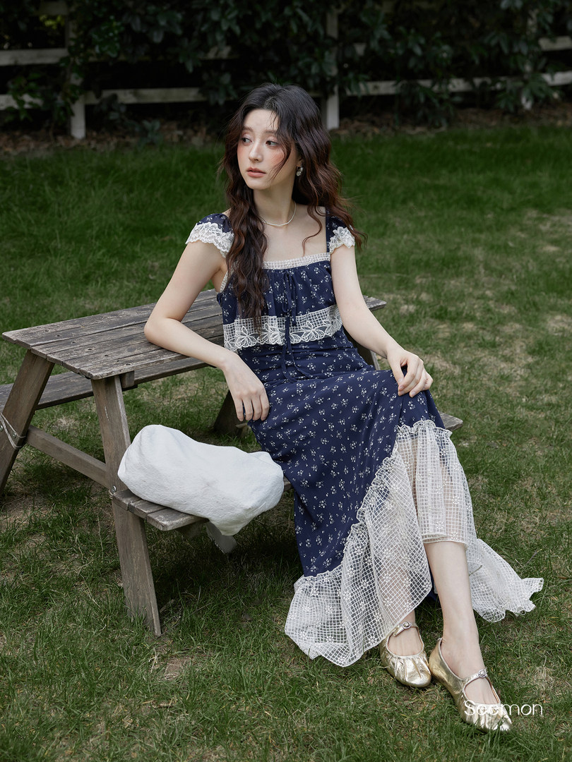 Model wearing a navy floral lace-trim dress outdoors