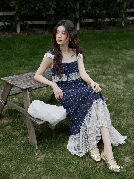 Model wearing a navy floral lace-trim dress outdoors