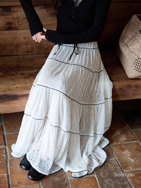 White tiered lace maxi skirt worn with a black long-sleeve top