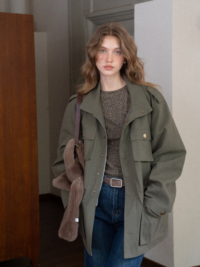 Woman wearing an olive green utility jacket with leopard print top and jeans