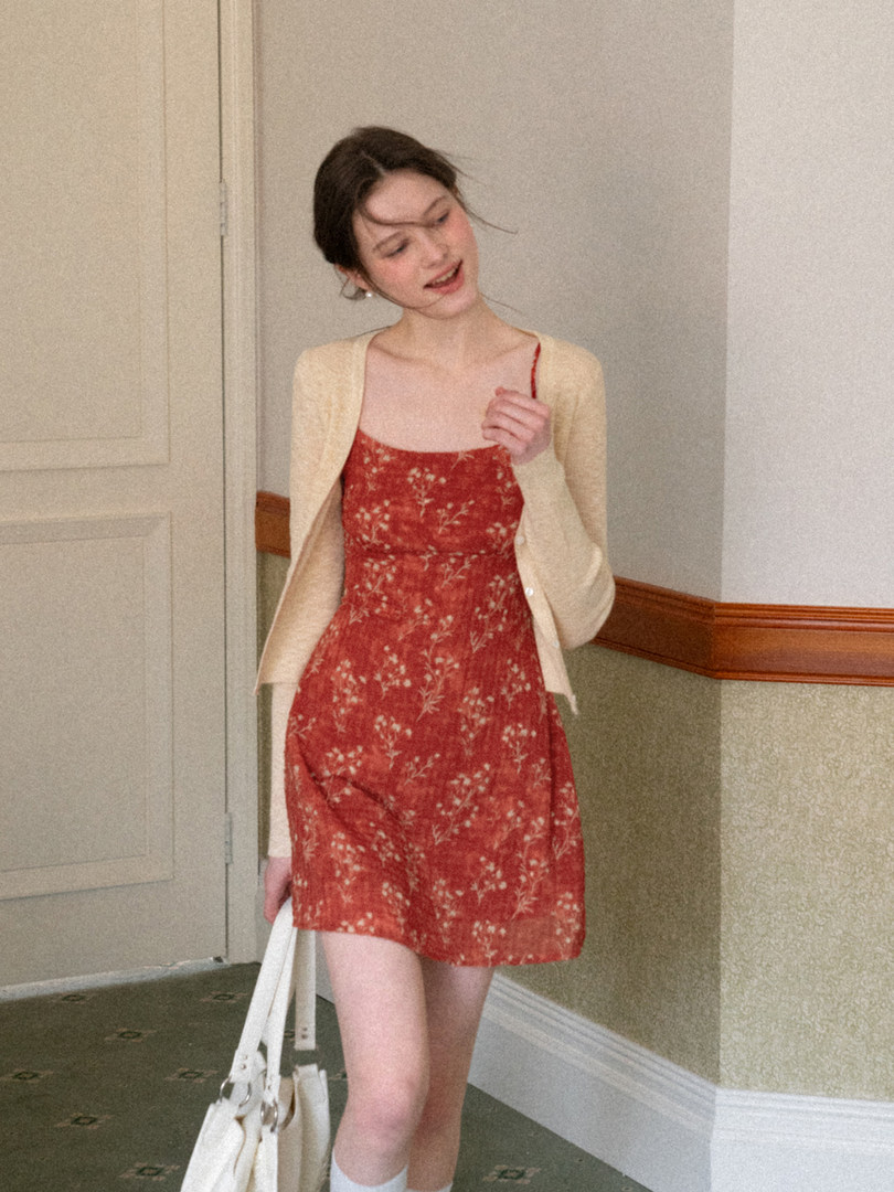 Woman wearing a red floral mini dress with a cream cardigan