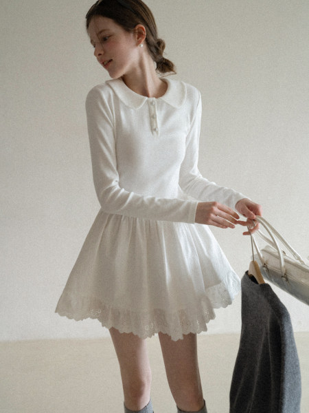 Woman wearing a white long-sleeve dress with a Peter Pan collar and lace hem