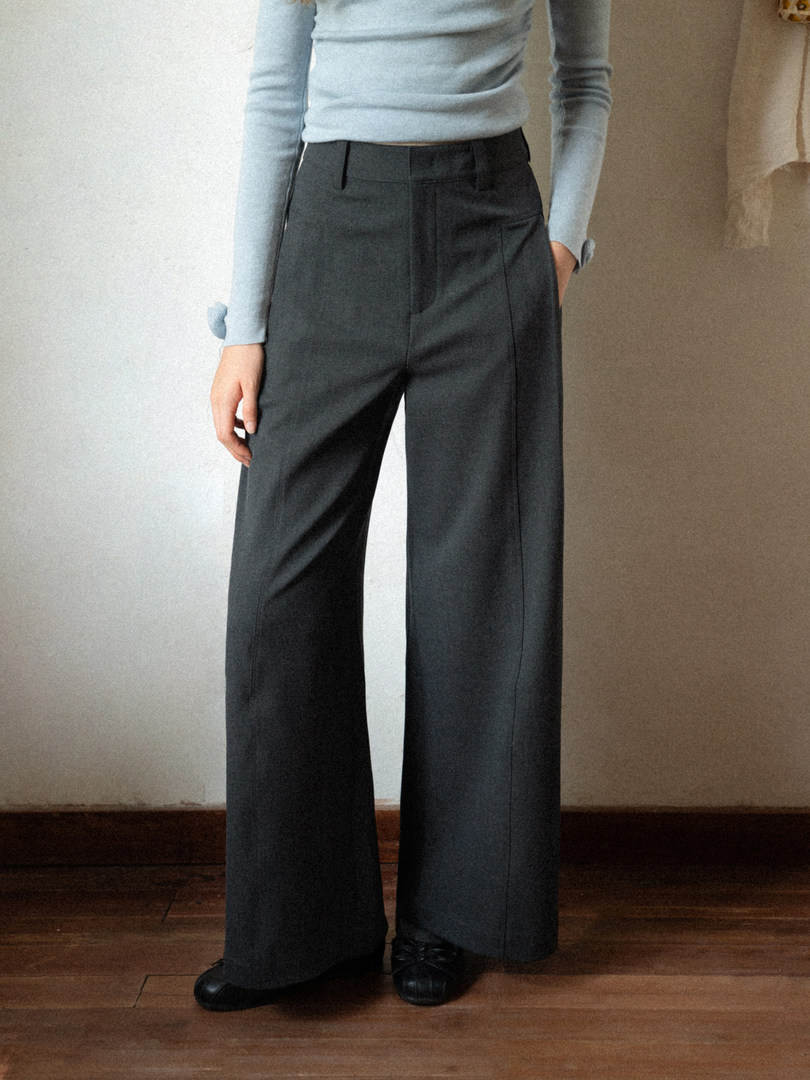 Model wearing dark wide-leg trousers with a light blue top