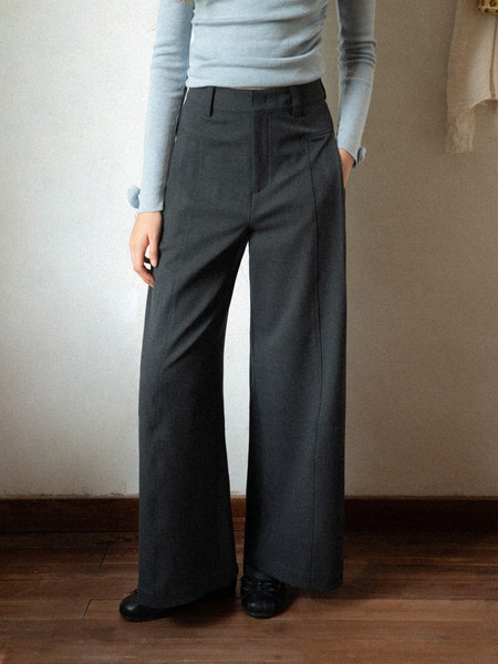 Model wearing dark wide-leg trousers with a light blue top