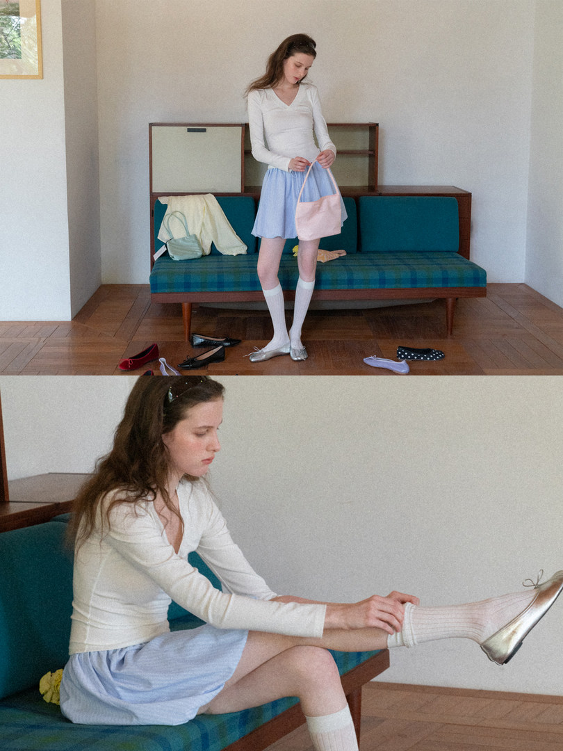 Model wearing a white long-sleeve top with a light blue skirt and metallic flats