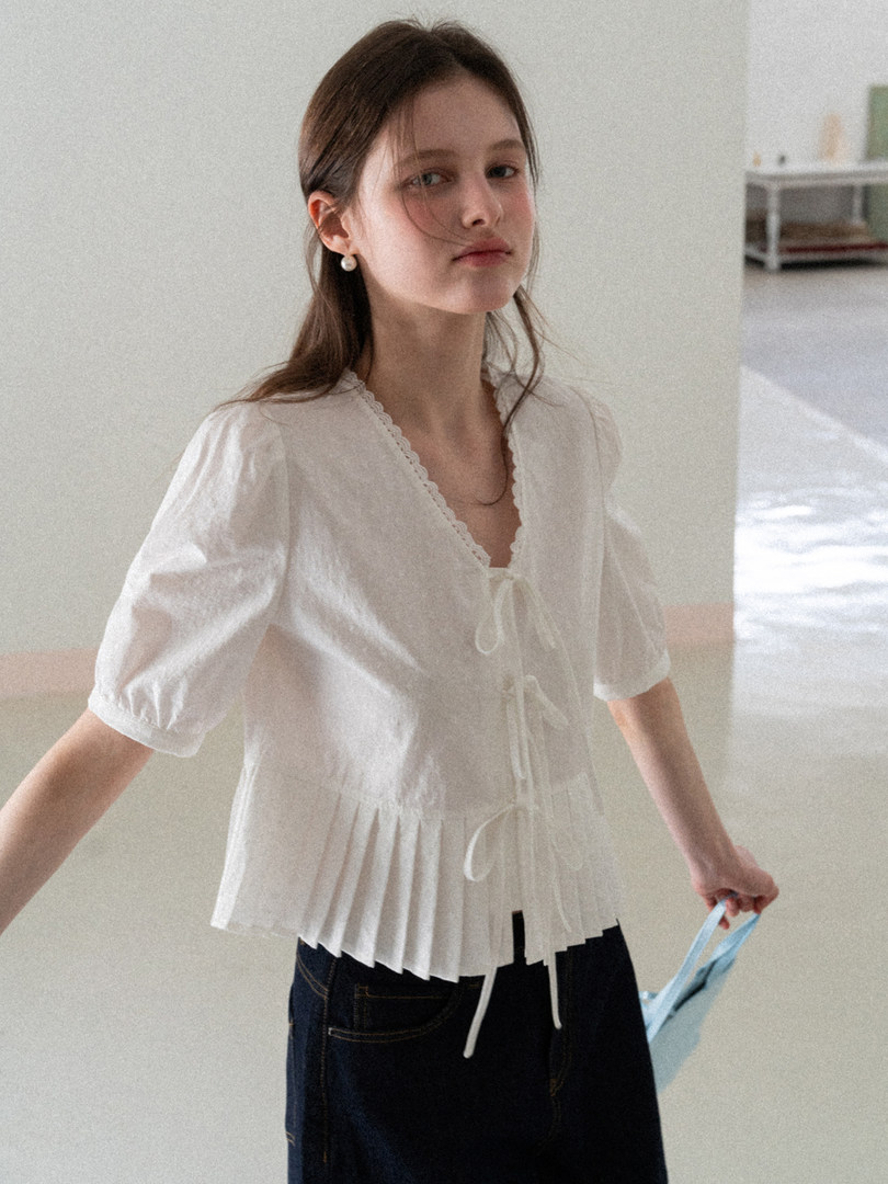 White short-sleeve tie-front blouse worn by a model