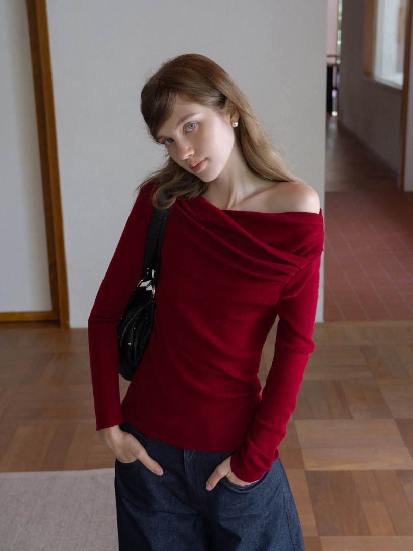 Model wearing a red off-shoulder long-sleeve top with jeans