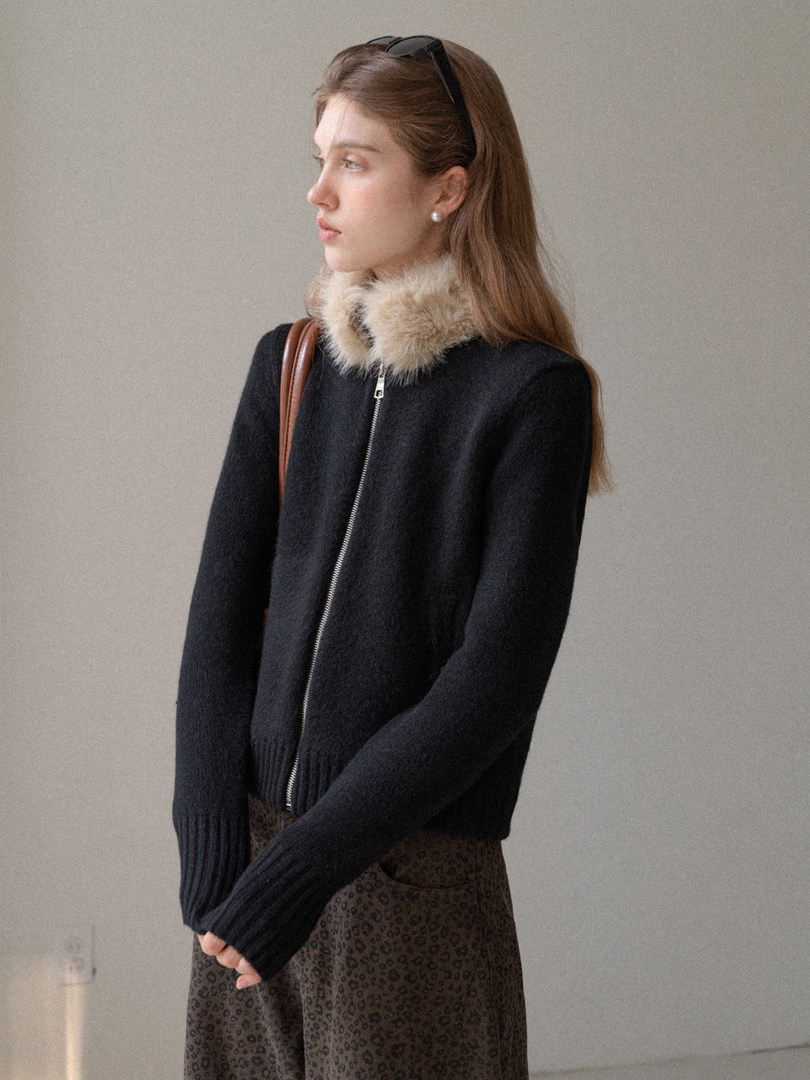 Model wearing a black zip-up jacket with a faux fur collar