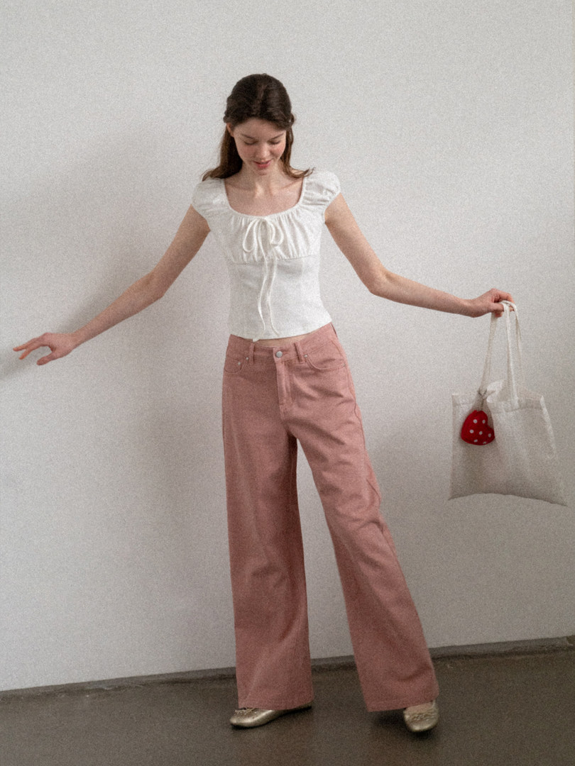 Model wearing a white short-sleeve top with pink wide-leg pants