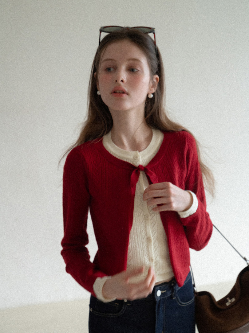 Red cropped cardigan worn over a cream buttoned top on a model