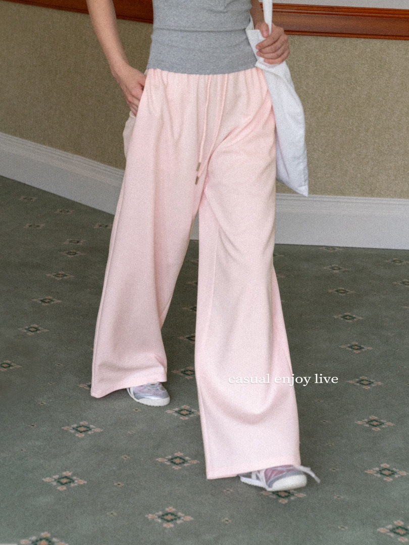 Model wearing light pink wide-leg pants with a gray top