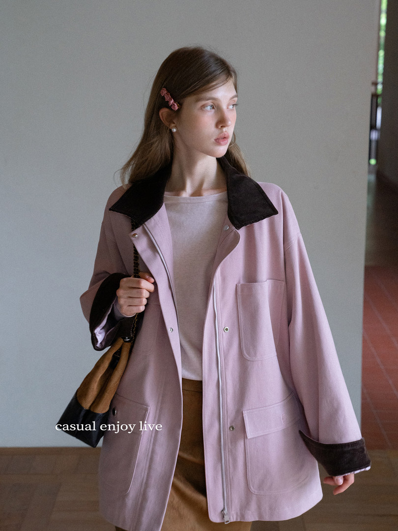 Model wearing a light pink oversized jacket with black collar and cuffs