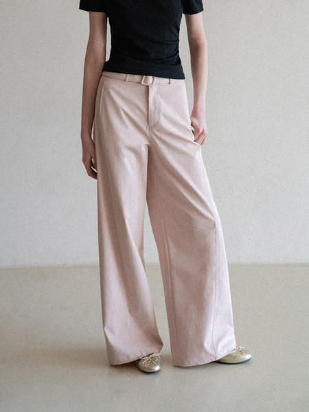 Model wearing high-waisted wide-leg beige trousers with a belt