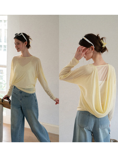 Model wearing a sheer pale yellow long-sleeve top with blue jeans
