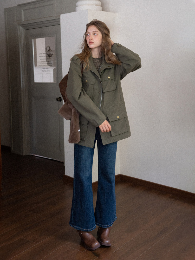 Model wearing an olive utility jacket with wide-leg blue jeans and brown boots