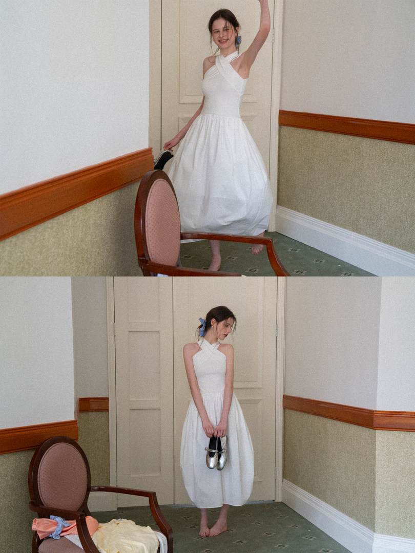 Woman wearing a white halter-neck dress in an indoor setting