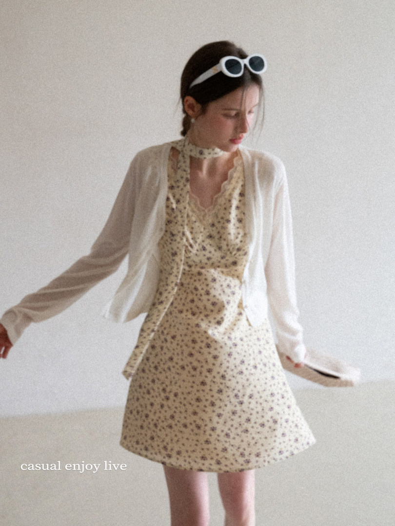 Model wearing a floral sleeveless dress with a light cardigan and headband