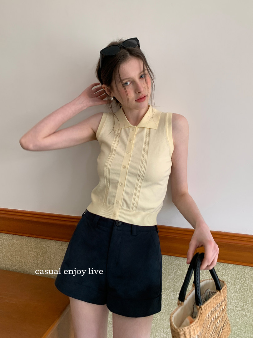 Model wearing a pale yellow sleeveless knit polo top with black shorts