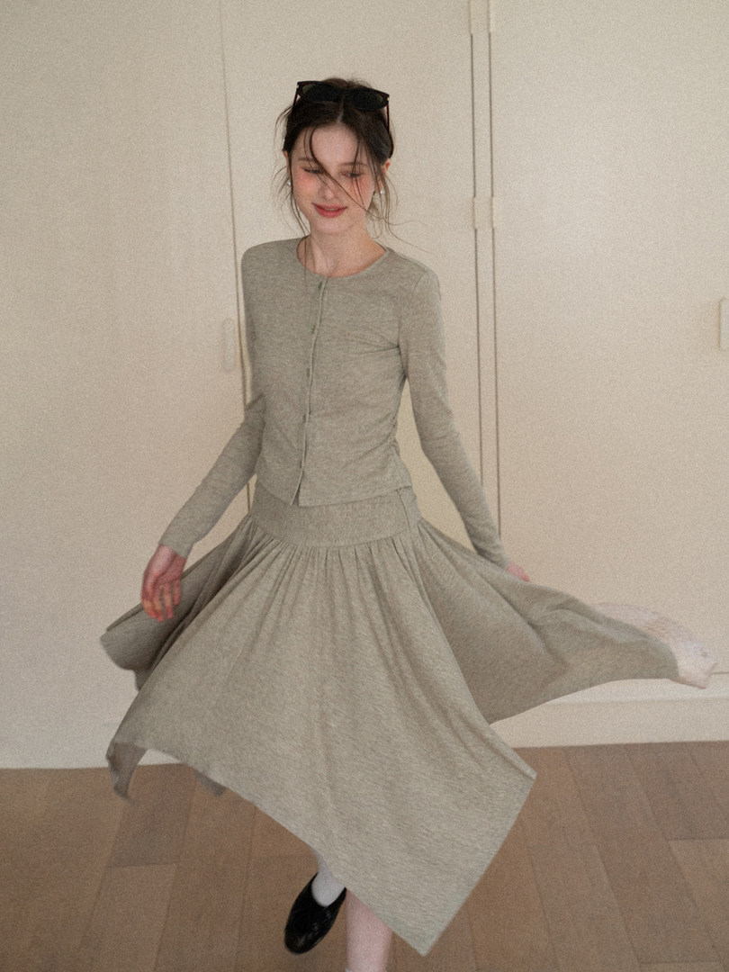 Woman wearing a light gray long-sleeve top and matching flowy skirt set