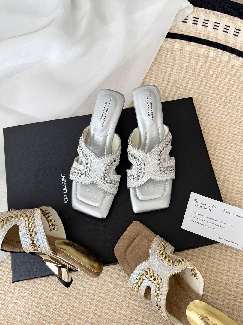 Pair of woven heeled sandals displayed on a box