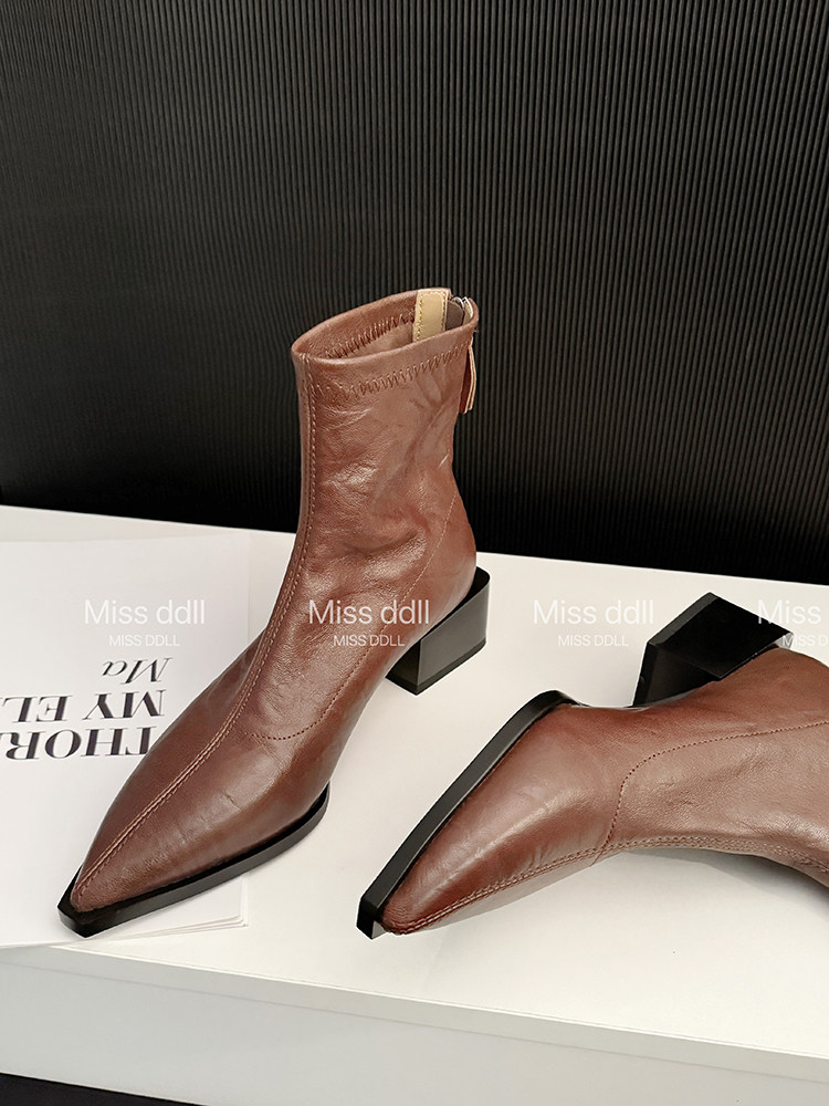 Brown pointed-toe ankle boots with block heels on a display surface