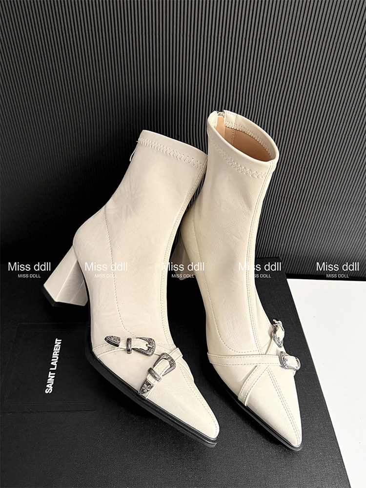 Pair of cream pointed-toe heeled ankle boots with buckle details