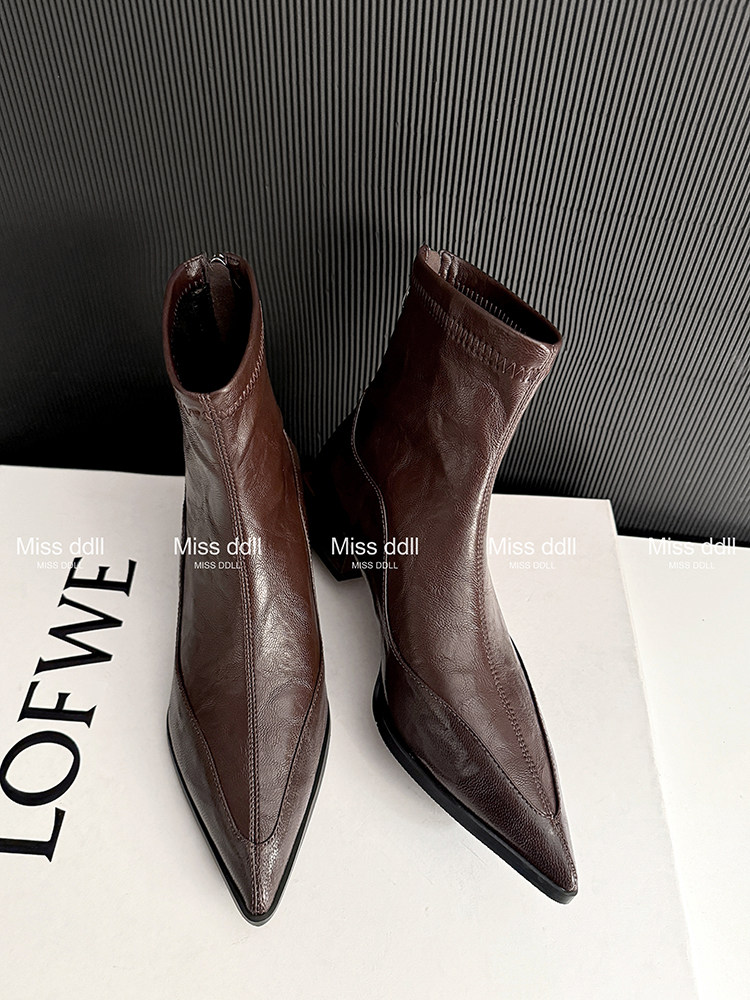 Brown pointed-toe ankle boots displayed on a box
