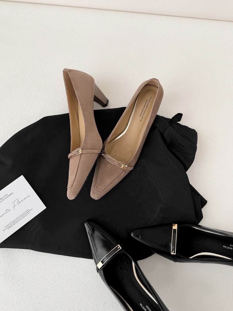 Pair of pointed-toe high-heel pumps in beige and black on a flat lay background