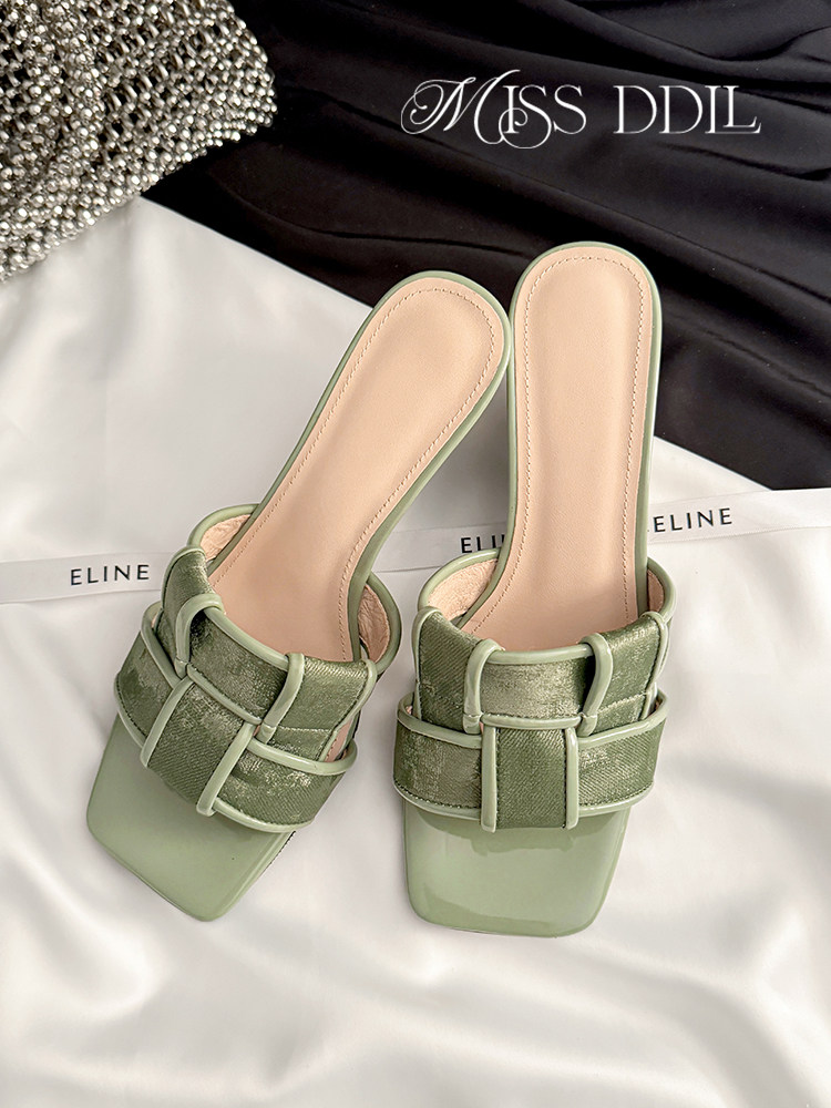 Pair of green strappy heeled sandals on a white background