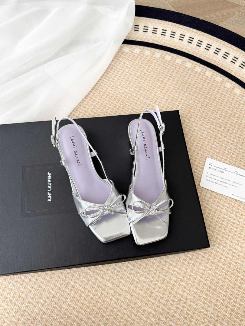 Silver strappy slingback heels displayed on a branded box