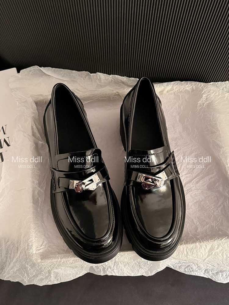 Pair of black glossy loafers with metal buckle detail