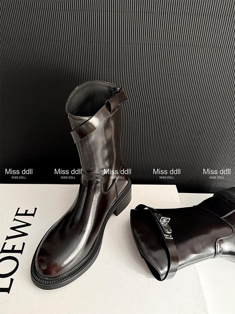 Black leather knee-high boots displayed on a box