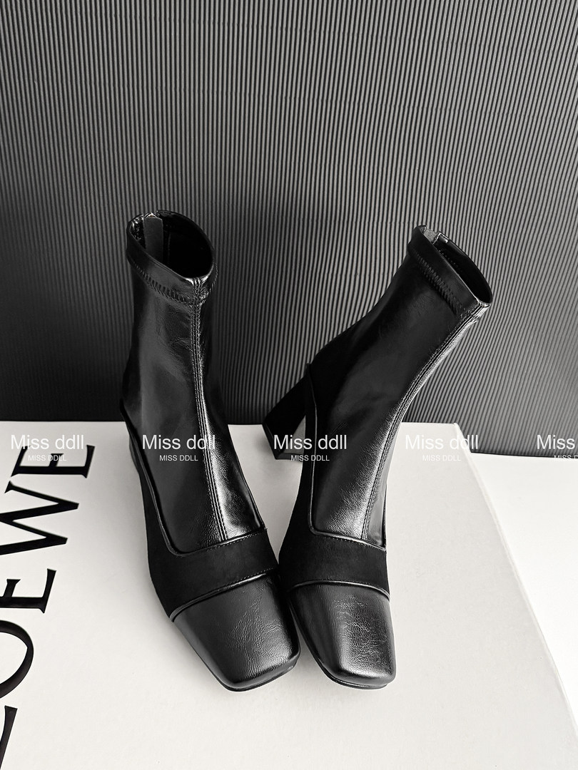 Black heeled ankle boots displayed on a surface