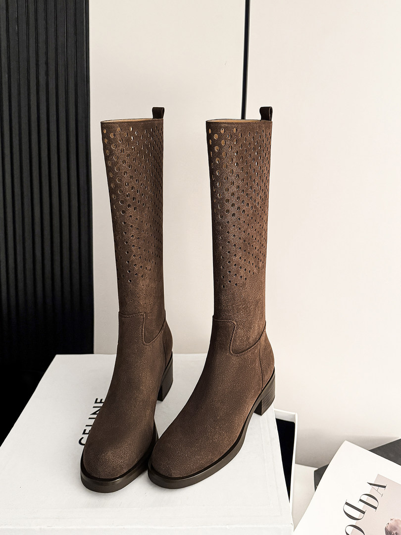 Brown knee-high perforated boots displayed on a box