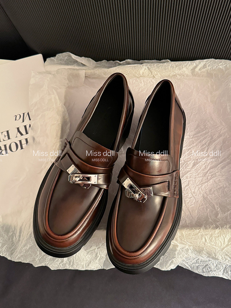 Pair of brown leather loafers with silver buckle detail