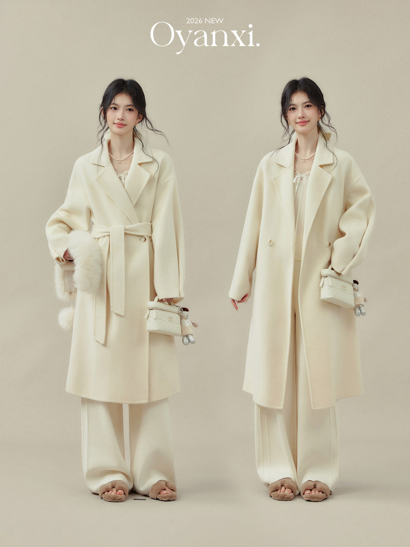 Two models wearing a cream belted coat and wide-leg pants with a matching outfit