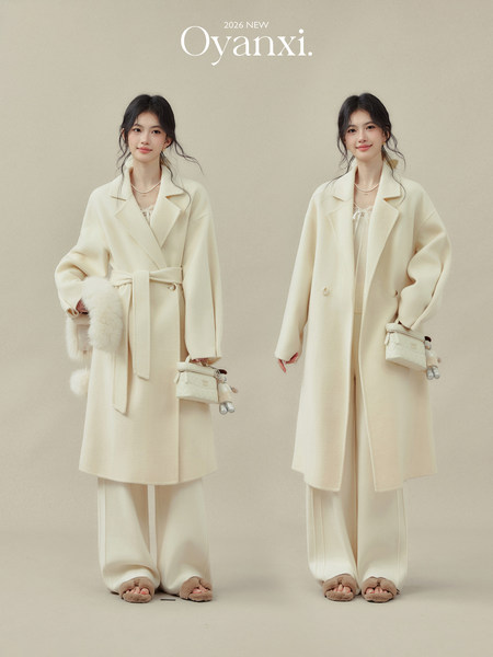 Two models wearing a cream belted coat and wide-leg pants with a matching outfit