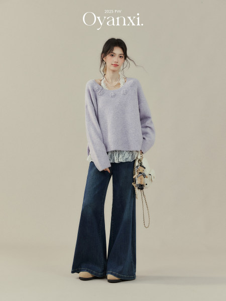 Model wearing a lavender sweater with wide-leg dark jeans in a fashion campaign image