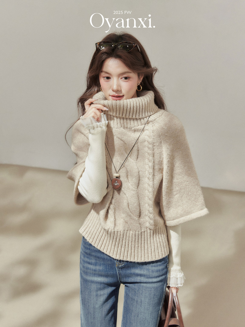 Model wearing a beige turtleneck knit sweater with blue jeans