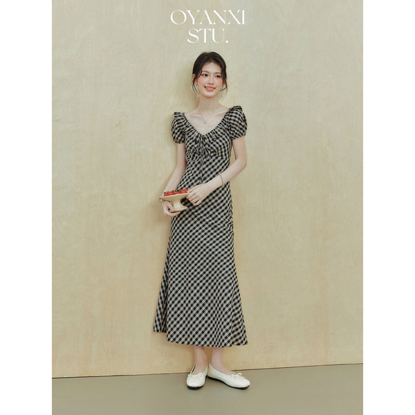 Woman wearing a black-and-white gingham midi dress with puff sleeves