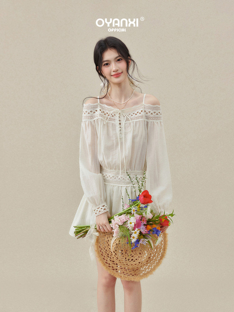 Model wearing a white off-shoulder lace-trim dress holding a flower basket