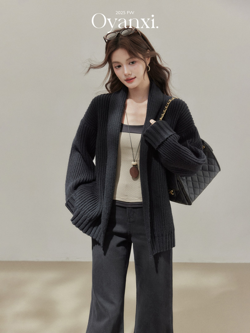 Model wearing a black ribbed cardigan outfit with a quilted shoulder bag