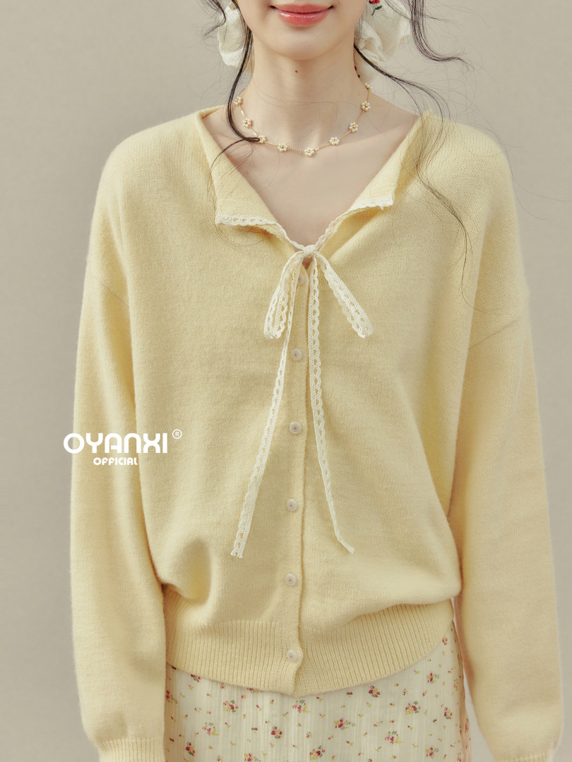 Model wearing a pale yellow button-front cardigan with lace tie detail