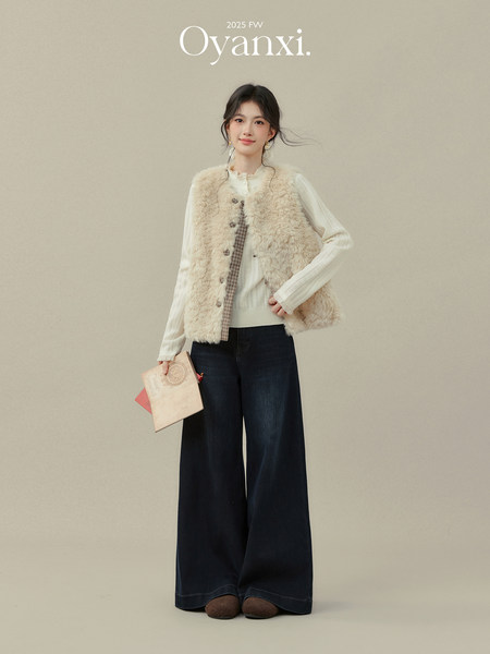 Model wearing a cream faux fur vest over a white top with wide-leg dark pants